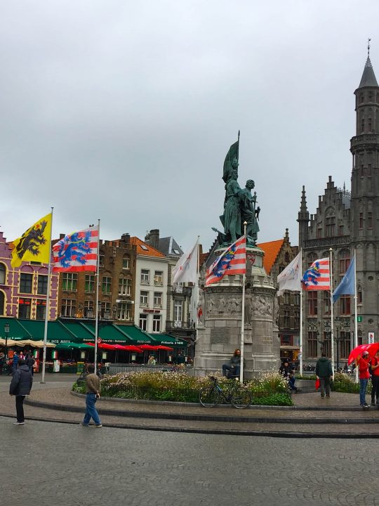 bruges belgium town square flags gothic