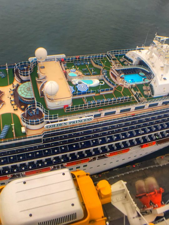Golden princess Cruise ship aerial view swimming pools top decks green grass carpet