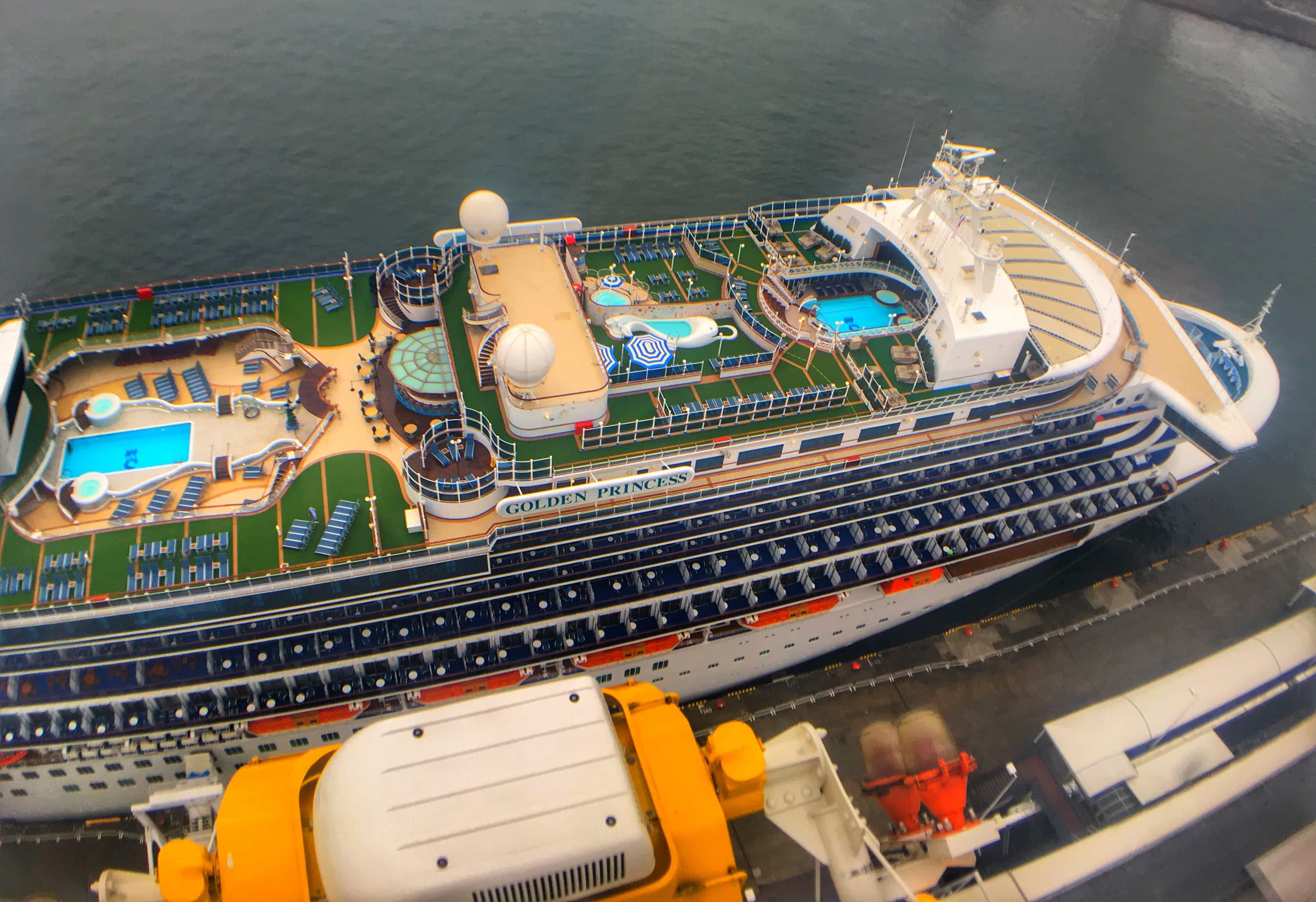 Golden princess Cruise ship aerial view swimming pools top decks green grass carpet 