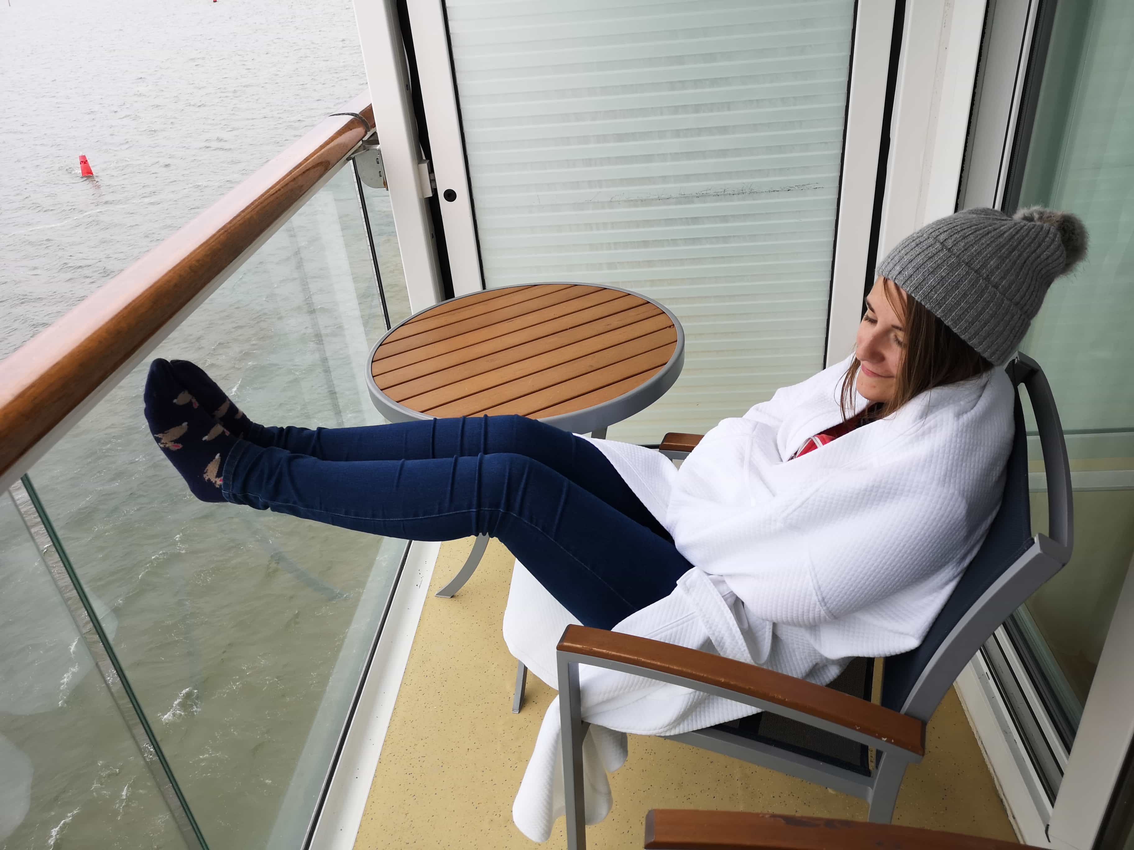 Marella Cruises Discovery Balcony Cabin Girl Wrapped up on Balcony with hat