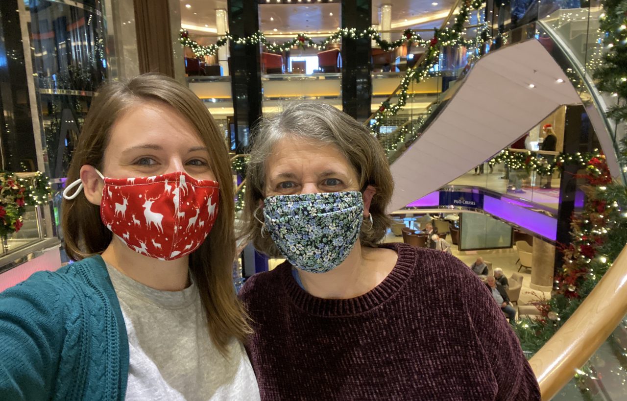 emma cruises and mum in atrium of p&O ventura wearing face masks surrounded by christmas decorations