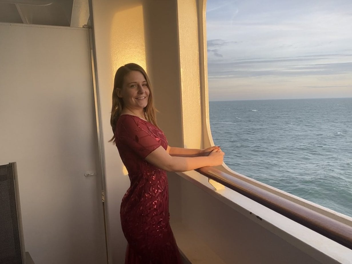 emma cruises on the balcony of the queen mary 2 on formal night in a red dress